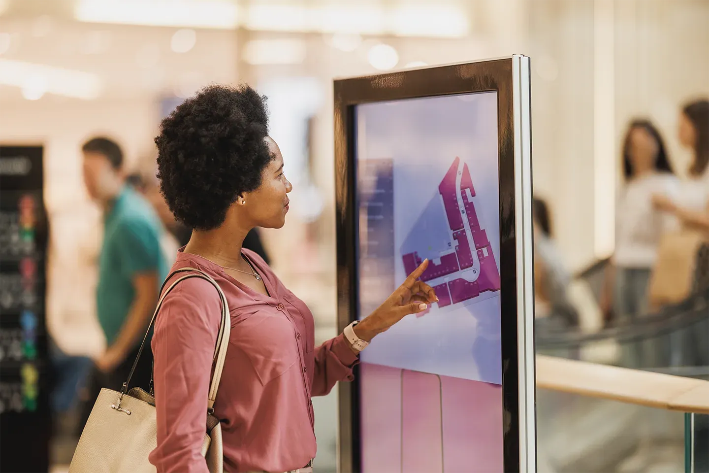 Woman using a touch screen digital map in a shopping mall.