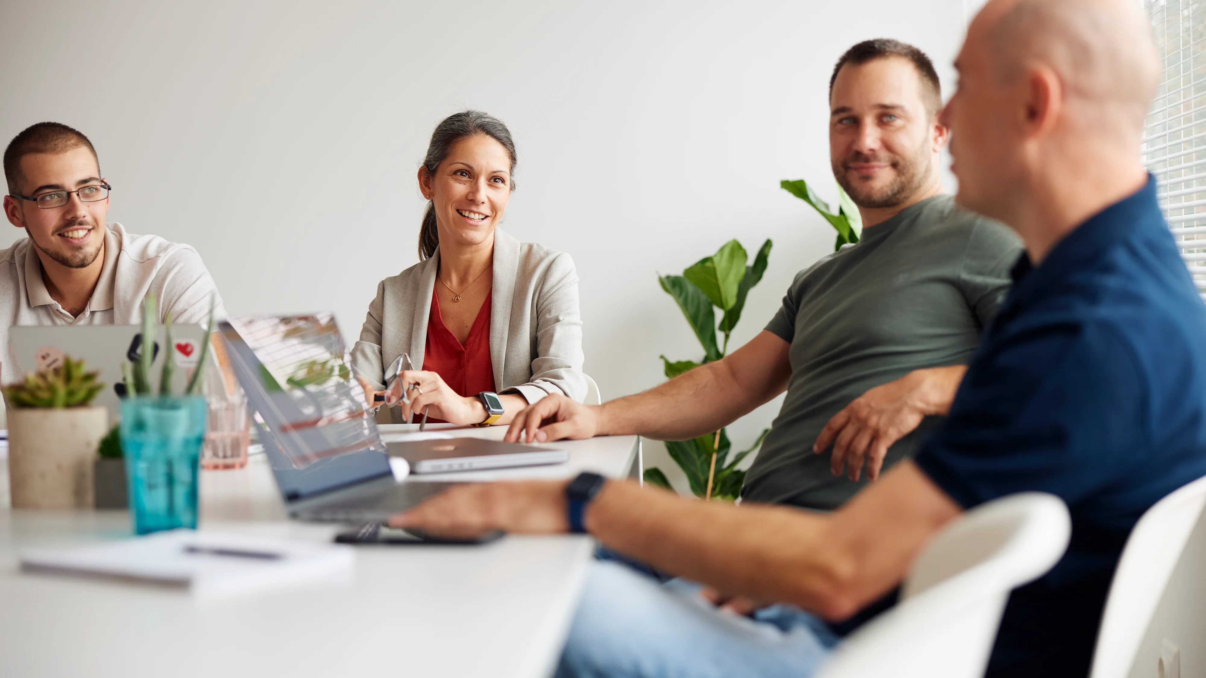 A group of people in a meeting, actively engaged in discussion, demonstrating assertive communication and confident body language